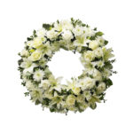 Complete crown for condolences in shades of white, with roses, gerberas and white lilies