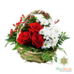 Rose rosse e bacche disposte in una cesta di Paglia BIO